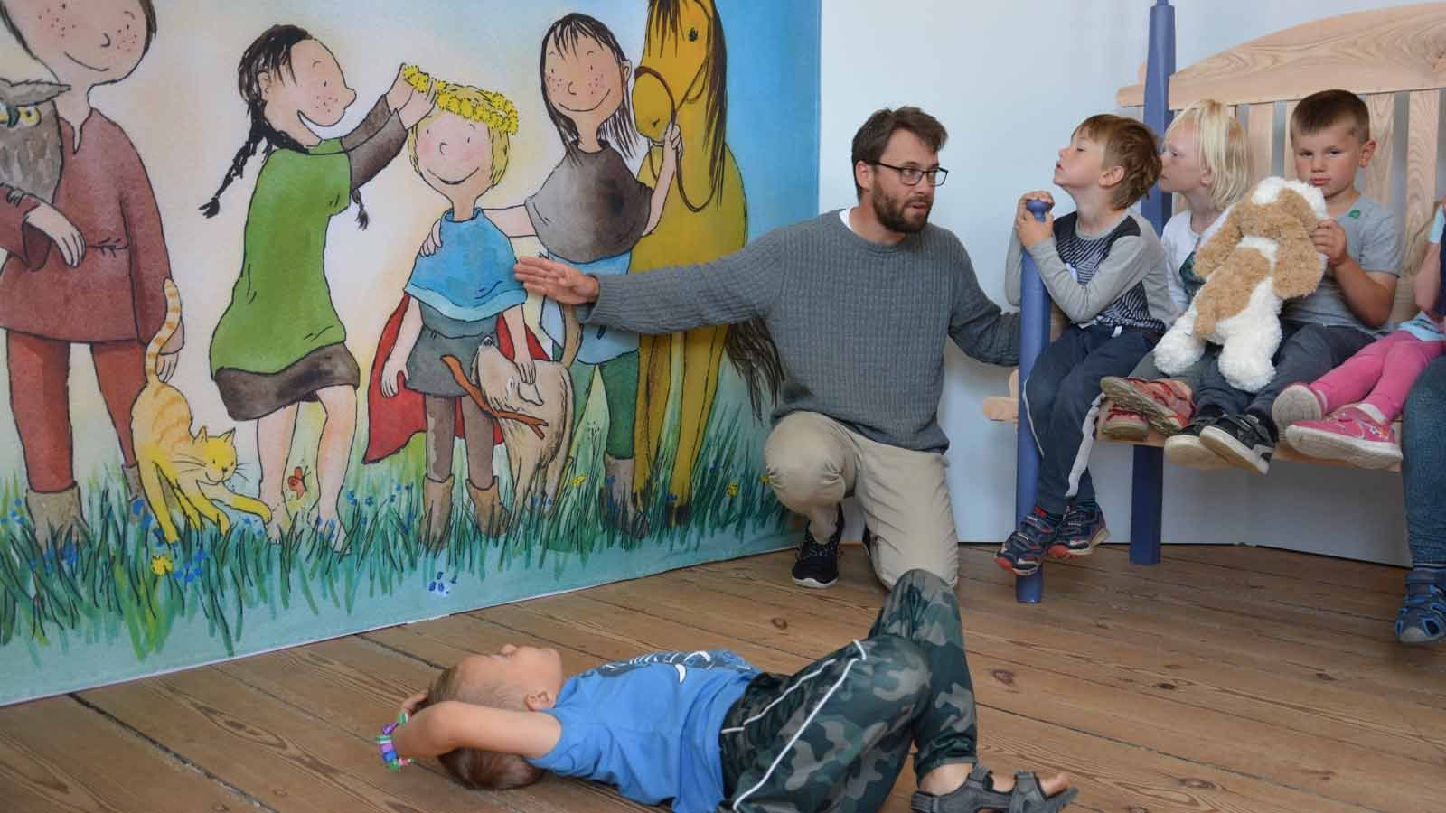 Børn høre på fortællinger i udstillingen