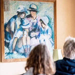 Gæster betragter et af malerierne på Malergården