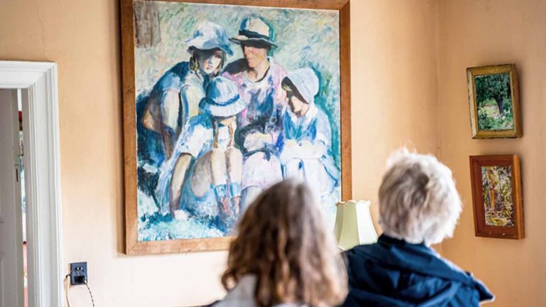 Gæster betragter et af malerierne på Malergården